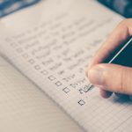 Student reviewing an ACT score report on a laptop while planning a June retake study schedule in a notebook