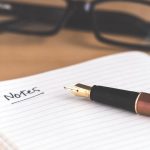 Open notebook with pen on a desk, representing IELTS Writing Task 2 essay practice