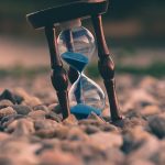 A clock beside study materials representing ACT section time management