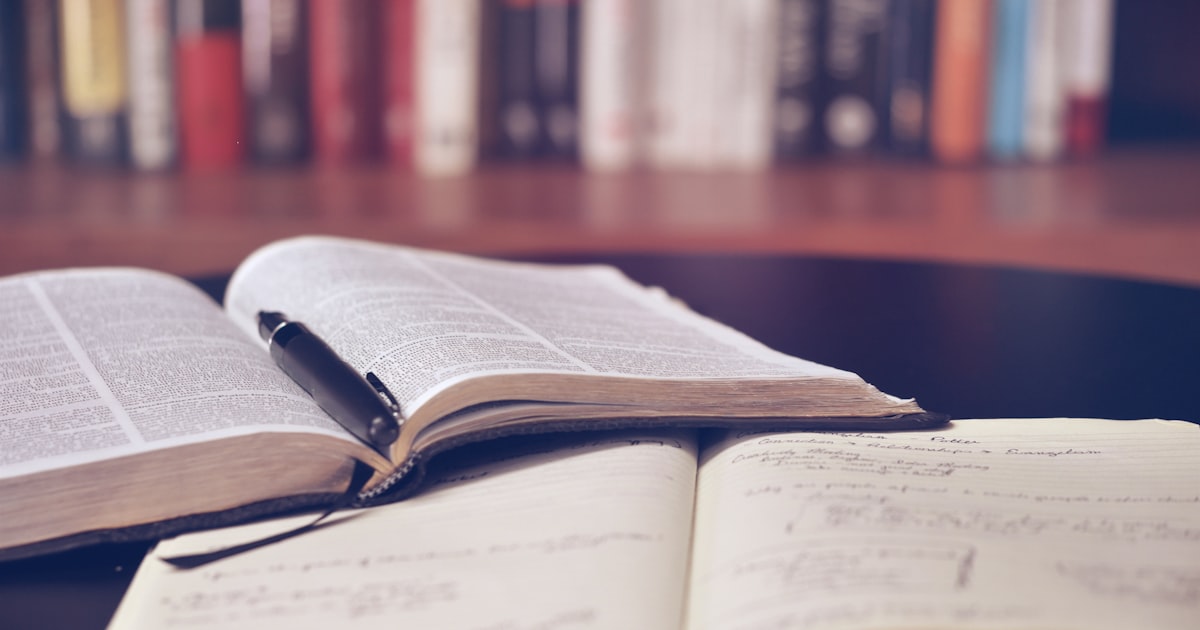 Student studying for the enhanced ACT English and Reading sections with notes and a book