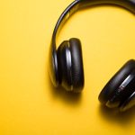 Student wearing headphones taking notes during a TOEFL Listening practice session