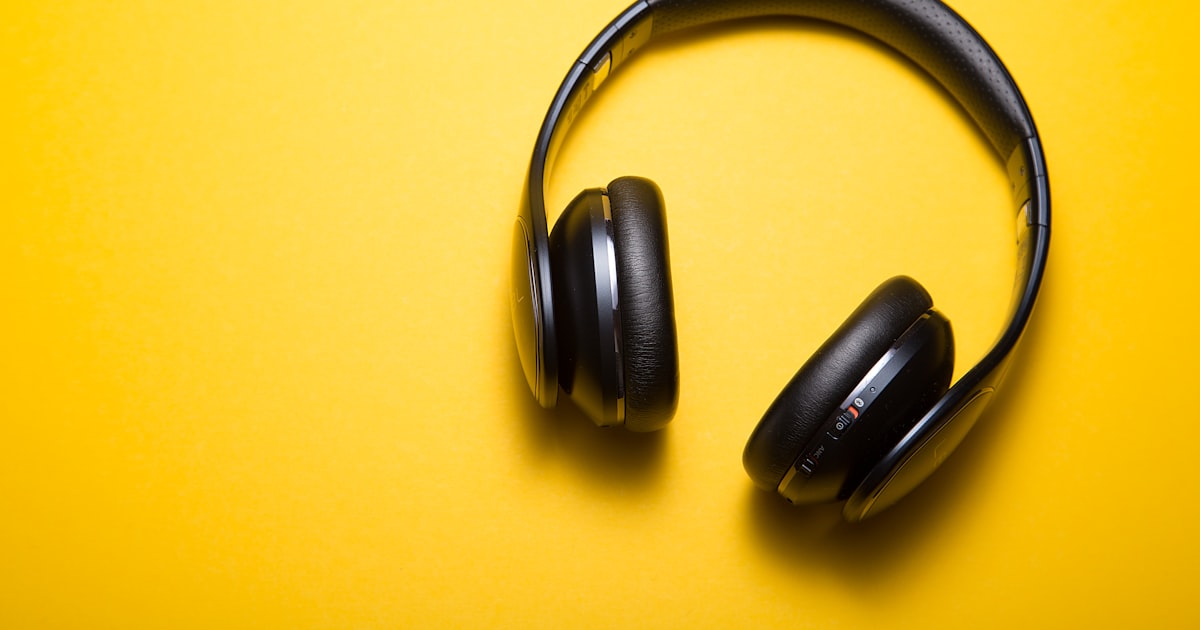 Student wearing headphones taking notes during a TOEFL Listening practice session