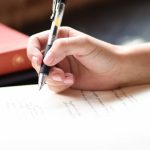 Student writing during an ACT test, deciding whether to take the optional Science section