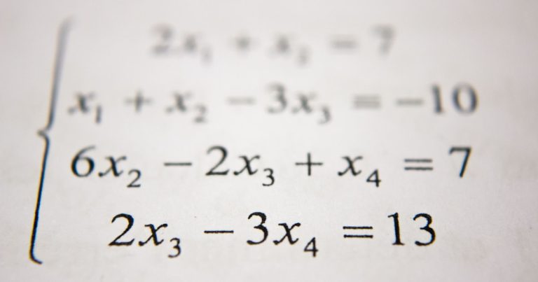Student using a graphing calculator while studying math problems for the Digital SAT