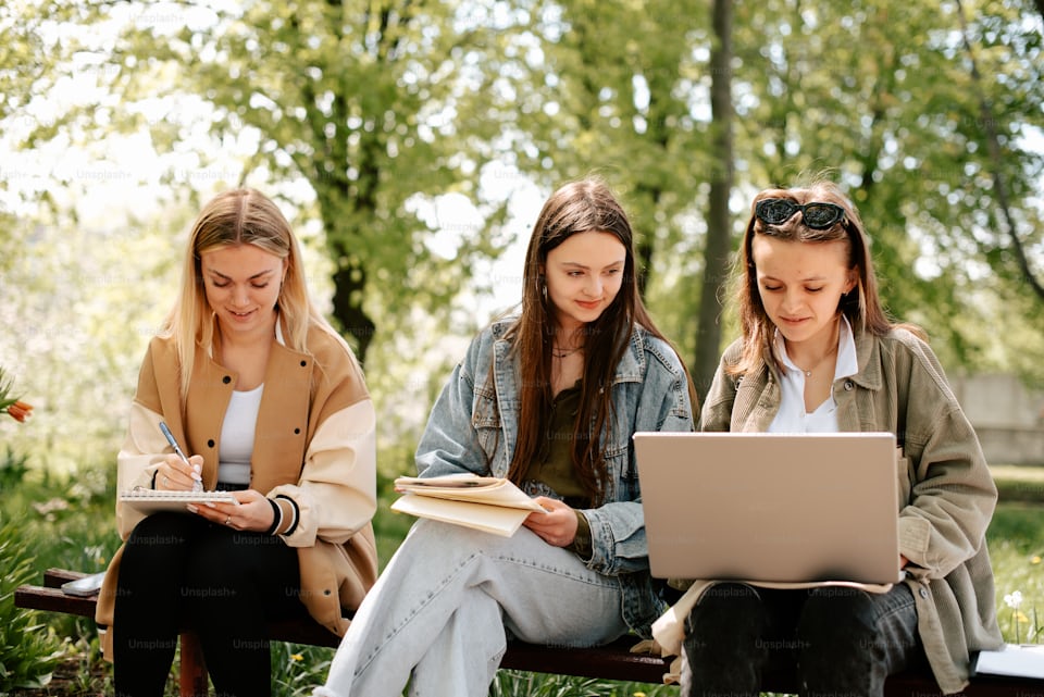 Three students sitting together reviewing college decision timeline and early application strategy
