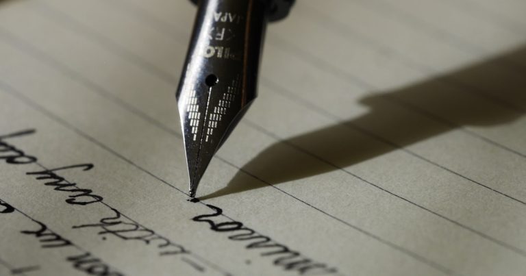 Fountain pen writing an essay in a notebook — IELTS Writing Task 2 practice