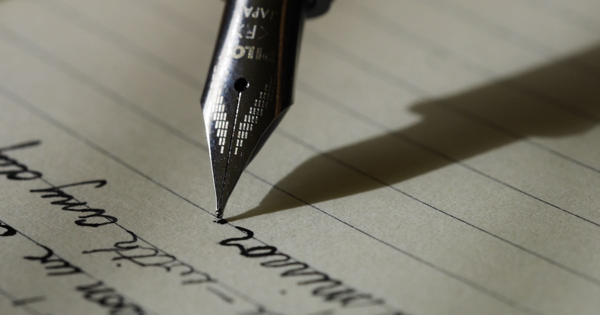 Student drafting a college personal statement essay by hand in a notebook