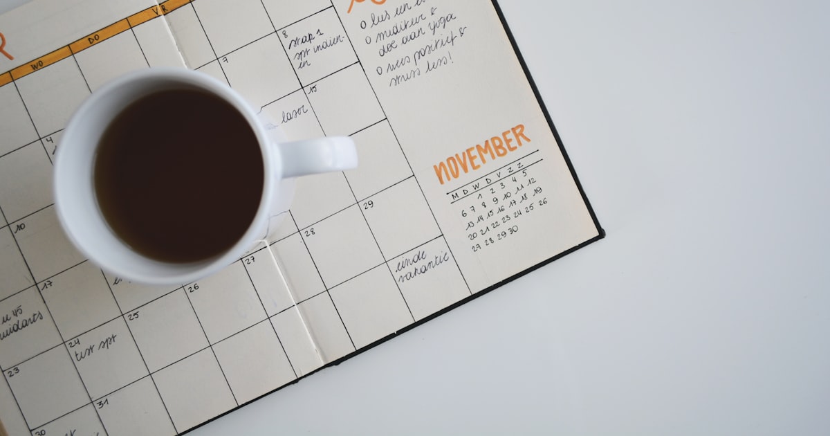A wall calendar and notebook on a desk, marking application deadlines for TOEFL and IELTS score reporting