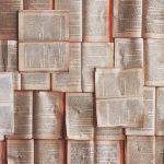 Wall of open book pages, representing TOEFL Reading passages, vocabulary and main idea practice