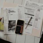 Financial paperwork, a calculator and a calendar on a desk, illustrating the CSS Profile and FAFSA deadlines that run alongside November 1 early application deadlines