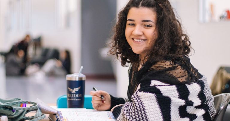 A high school student working through Digital SAT math practice problems at a desk