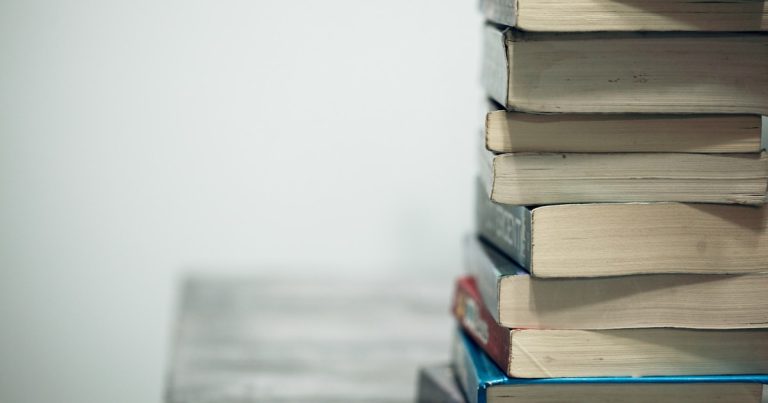 Stack of well-worn books symbolizing close reading and word study for Digital SAT vocabulary prep
